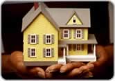Person holding a little house in hands